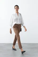 Pantalón de vestir negro de corte recto, con cintura estructurada y costura central vertical en las piernas que aporta un acabado sastrero.