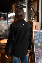 Chaqueta de gamuza marrón con diseño de flecos en la parte delantera y las mangas, corte tipo camisa y cierre frontal de botones.