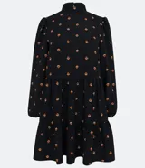 Vestido corto negro de chiffon con estampado de pequeños corazones naranjas, cuello alto, mangas largas abullonadas y falda con volados en capas.