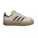 Championes Adidas Gazelle Bold color beige con detalles en azul marino y suela de goma marrón de plataforma.