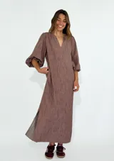 Vestido largo color azul con textura arrugada, escote en V y mangas 3/4 abullonadas.