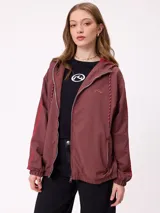 Campera rompevientos color bordó con cierre frontal, capucha con cordones ajustables y franjas laterales en tono más oscuro. Presenta puños elásticos y bolsillos frontales.