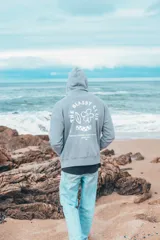 Hoodie gris con estampado en la espalda que incluye texto y dibujos.