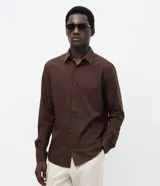 Camisa de corte slim, manga larga, con cuello camisero y cierre frontal de botones. Confeccionada en tejido plano de bambú, viscosa, poliéster y elastano.