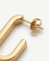 Caravanas tipo argolla de forma rectangular, fabricadas en acero con acabado dorado.
