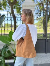 Bolso tipo tote bag color camel, confeccionado en cuero gamuzado.