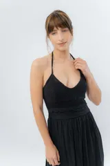 Vestido largo negro con top tejido en crochet y falda de gasa liviana con caída natural. Escote halter con breteles que atan al cuello y detalle de puntilla en la unión del busto.