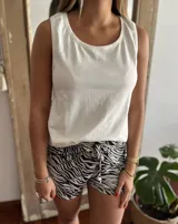 Pijama de dos piezas compuesto por musculosa blanca de breteles finos y short estampado con diseño animal print cebra en blanco y negro.