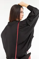 Camisa negra de satén con cuello clásico, corte holgado y cierre frontal con botones blancos.