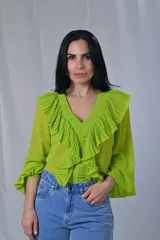 Camisa color verde lima de mangas largas con volados plisados en el frente y cuello en V.