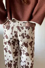 Pantalón de jean color beige con estampado de manchas marrones tipo vaca, de corte wide leg y tiro medio.