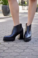 Botinetas de cuero negro con taco ancho, plataforma delantera y diseño con boca en V en el tobillo.