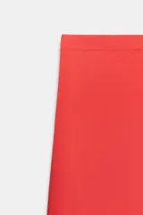 Falda corta de punto con cintura elástica y diseño en evasé de color rojo.