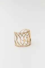 Pulsera tipo brazalete dorada con diseño calado de círculos entrelazados.
