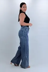 Pantalón jean wide leg de tiro alto en color azul, con diseño de costuras diagonales contrastantes en el frente y corte amplio en las piernas.