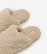 Pantufla cerrada de mujer con textura de peluche suave en color negro, diseñada para brindar comodidad en el hogar.