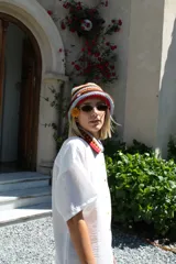 Gorro tipo bucket tejido al crochet con rayas horizontales en colores celeste, marrón, naranja y rojo.