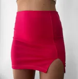 Minifalda negra de crepe, tiro alto, corte ajustado y tajo lateral.