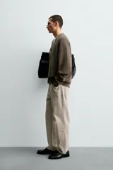 Cárdigan de hombre color negro, de corte regular fit, tejido en estructura compacta, con cuello pico, manga larga y cierre frontal de botonadura.