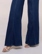 Jean wide leg de tiro alto en denim azul claro, con calce ajustado en la cadera, costuras verticales frontales y bolsillos estilo carpintero.