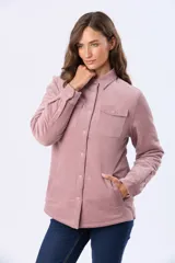 Campera de pana color rosado con interior de corderito sintético. Cuenta con cierre frontal de botones metálicos, cuello camisero, bolsillos con solapa en el pecho y mangas largas.