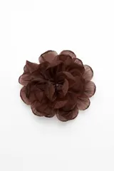 Broche en forma de flor confeccionado en tela semitransparente con múltiples capas de pétalos.