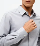Camisa de corte regular, color gris claro, con cuello inglés, manga larga y cierre frontal con botones. Confeccionada en una mezcla de algodón y poliéster, presenta un diseño clásico y versátil de la marca Marfinno.