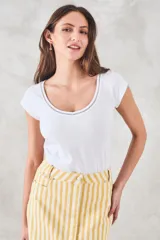 Remera de algodón peinado color camel, con ajuste al cuerpo, escote redondo con detalle calado y mangas cortas.