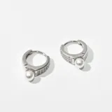 Par de aros plateados tipo argolla con incrustaciones de strass y dije colgante de perla.