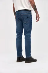 Jean de corte slim, con ajuste en cadera y muslos, y pierna levemente entallada desde la rodilla hasta el tobillo. Presenta un lavado azul medio clásico con costuras reforzadas.