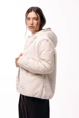 Campera con capucha, cuerpo de pelo sintético y mangas matelaseadas con cierre frontal.