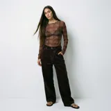 Pantalón de corte recto y tiro alto confeccionado en pana color marrón chocolate, con diseño de cinco bolsillos y cierre frontal con botón y cremallera.