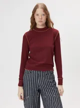 Polera de manga larga confeccionada en tejido rib, con calce ajustado al cuerpo y cuello alto.