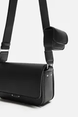 Bandolera negra con acabado grabado, compartimento principal con cierre de solapa imantada, bolsillo interno con cierre y bolsillo frontal con cierre. Incluye asa de hombro ajustable y monedero.