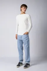 Jean de corte mom oversize, color negro lavado, con diseño de cinco bolsillos y cierre frontal con botón y cremallera.