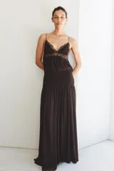 Vestido largo de tirantes finos con escote en pico, cuerpo con frunces elásticos y detalle de encaje a tono en la parte superior. Cuenta con forro interior y falda fluida.