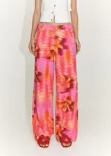 Pantalón de jean estilo wide leg con tiro medio, cierre de cremallera y botón. Presenta un diseño estampado con rayas horizontales y flores, confeccionado en tejido de algodón.