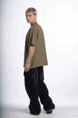 Remerón de jersey pesado color verde oliva, con cuello redondo y manga corta. Presenta un estampado sutil en el pecho y un estampado más grande en la espalda.