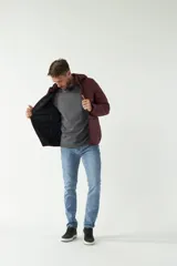 Campera de nylon color bordó con cuello, capucha removible y bolsillos laterales con cierre.