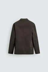 Blazer de corte relajado confeccionada en mezcla de algodón con acabado efecto lavado. Presenta cuello con solapas de muesca, cierre frontal con dos botones, bolsillo de vivo en el pecho y bolsillos con solapa en la cadera. Diseño sin forro interior con aberturas en la espalda.