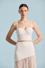 Bustier blanco de corte estructurado estilo corsé, con copas con aro y tirantes finos regulables.