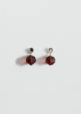 Pendientes cortos dorados con un cristal superior redondo y un dije colgante de cristal marrón translúcido con tallado facetado esférico.