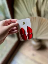 Aros colgantes con forma de pétalos rojos y detalle de strass.