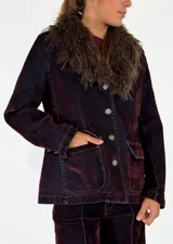 Chaqueta de denim azul oscuro con cuello de piel sintética desmontable, cierre frontal con botones metálicos y bolsillos delanteros con solapa.