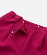 Pantalón de sastrería modelo pantalona, color fucsia, con corte amplio y recto. Presenta cintura con botón, elástico en la parte trasera para mayor ajuste y bolsillos laterales tipo cuchillo.