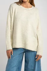 Sweater de tejido de punto color bordó, con cuello redondo, mangas largas y puños acanalados. Presenta un diseño de corte recto y textura suave.