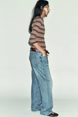 Jersey de punto fino con diseño a rayas horizontales en tonos tierra, bordó y celeste. Presenta cuello redondo, cierre frontal con botones y mangas por debajo del codo.