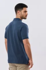 Remera polo lisa de piqué en color bordó, con cuello camisero, cierre frontal con botones y mangas cortas.