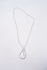 Collar con cordón gris y dije colgante de metal plateado con diseño de gota texturizada.