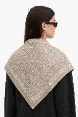 Pañuelo cuadrado de satén color mostaza con estampado floral y geométrico en blanco.